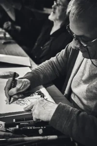 Georges Van Linthout dessinant lors d’une dédicace
