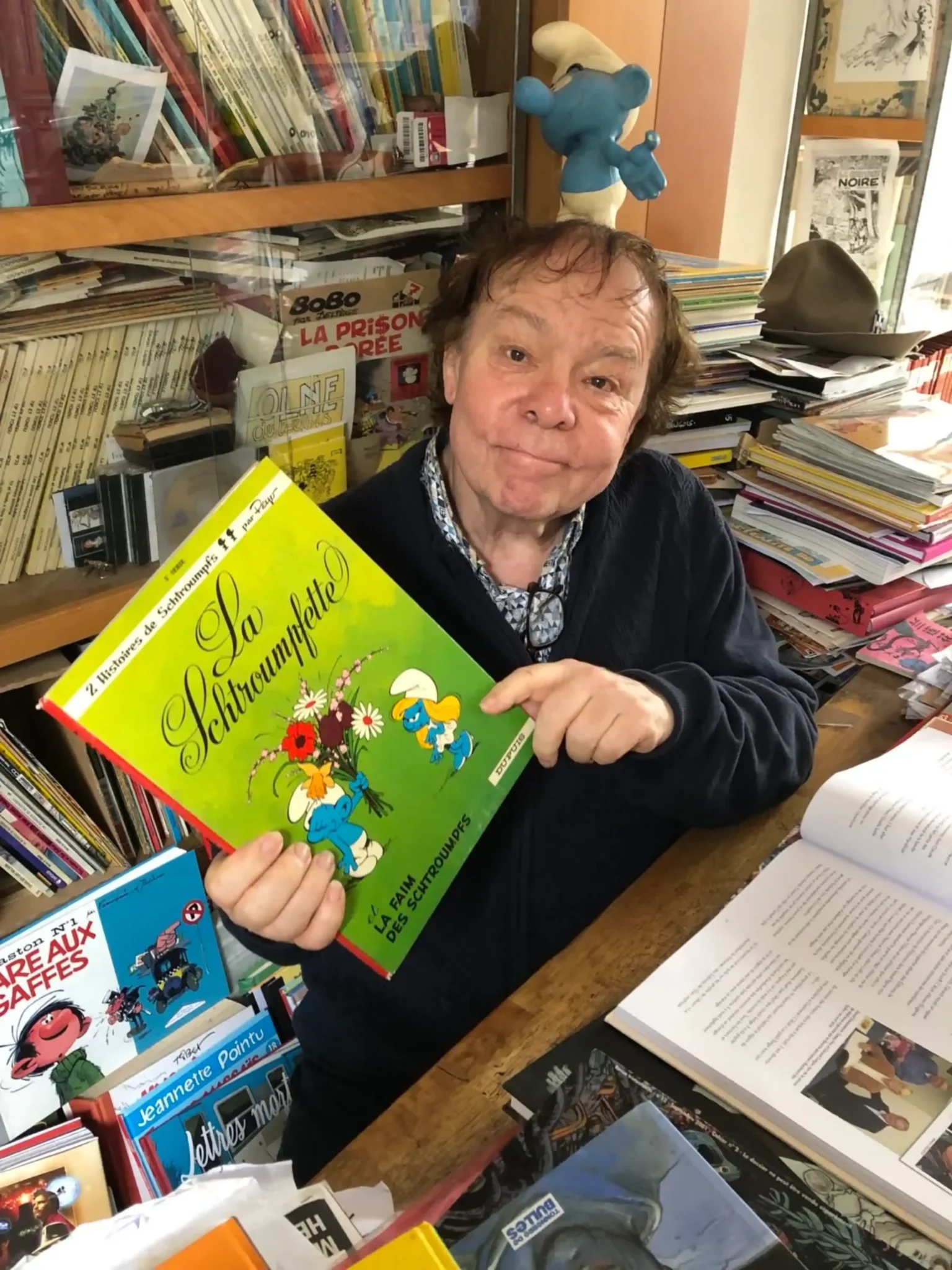 François Walthéry présentant un album des Schtroumpfs